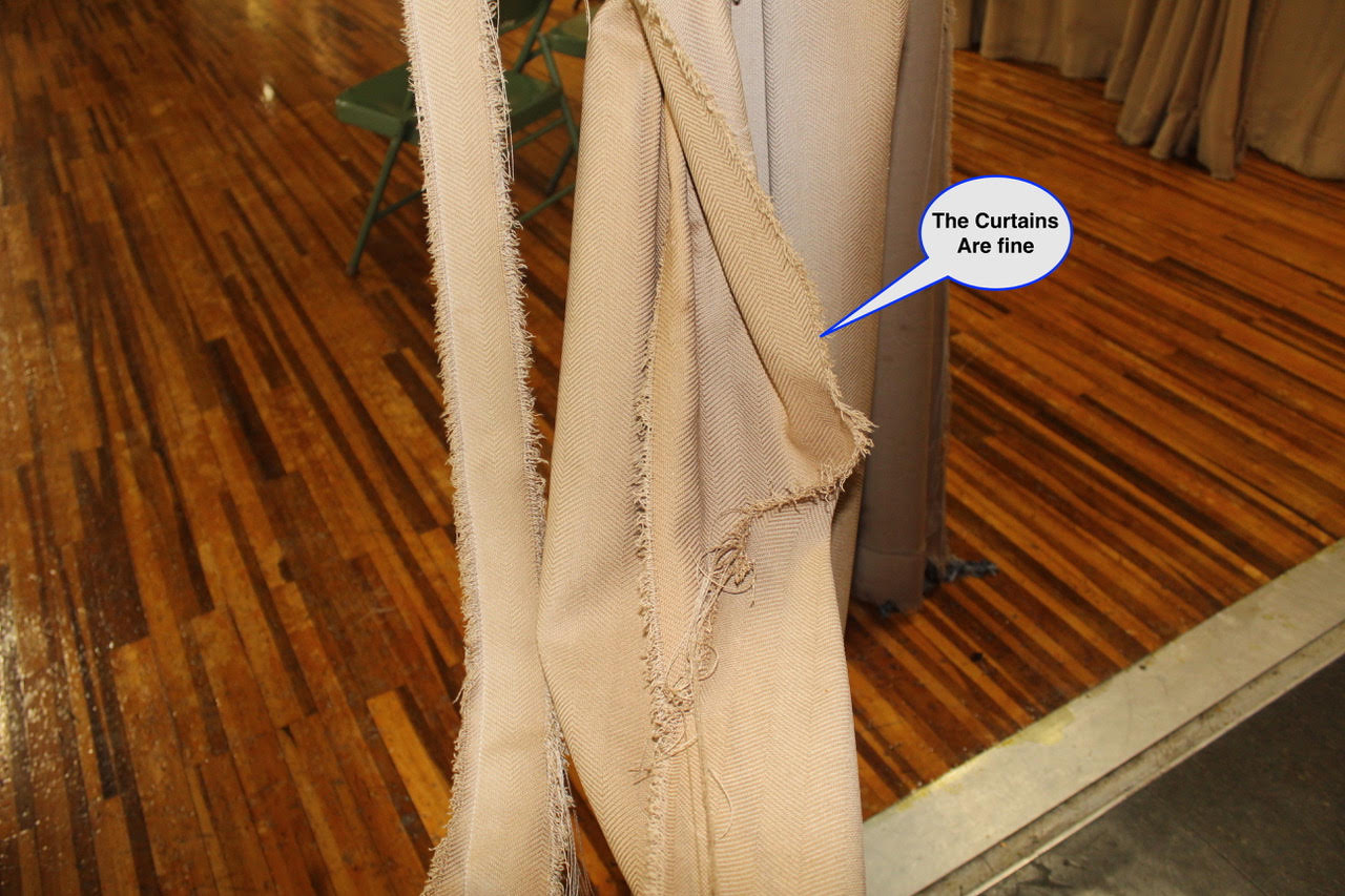 WOS August 8 Beige fabric strips with frayed edges hanging indoors over a wooden floor; a speech bubble reads, 'The Curtains Are fine.'